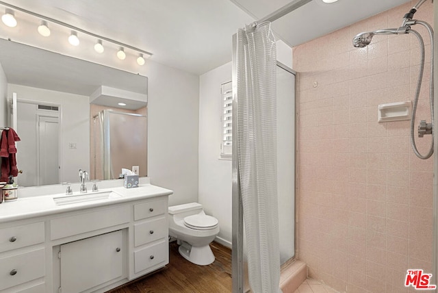 bathroom with toilet, vanity, hardwood / wood-style floors, and a shower with curtain