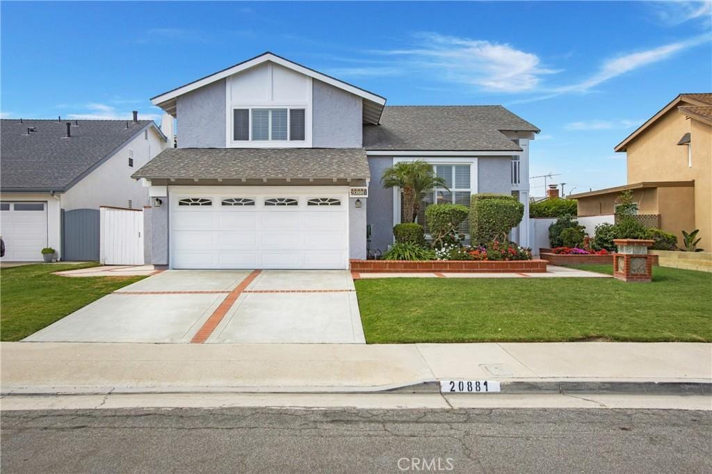 front facade with a front yard and a garage