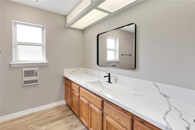 bathroom featuring heating unit, wood-type flooring, and vanity