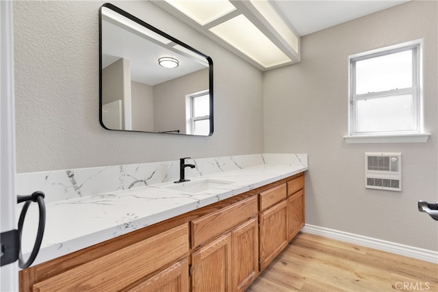 bathroom with wood-type flooring, vanity, heating unit, and plenty of natural light