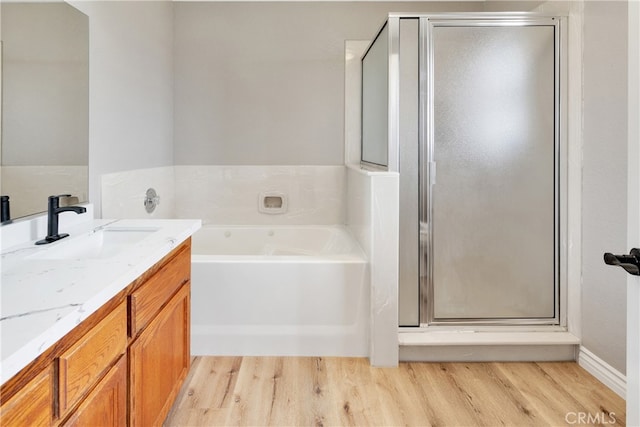 bathroom with independent shower and bath, vanity, and hardwood / wood-style flooring