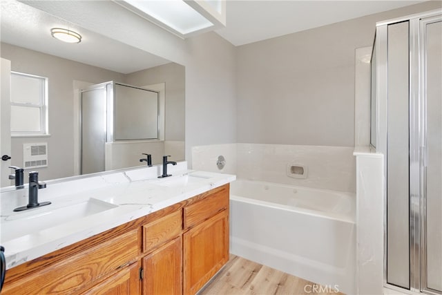 bathroom featuring wood-type flooring, vanity, and shower with separate bathtub