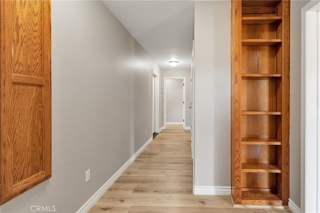 corridor with light hardwood / wood-style floors