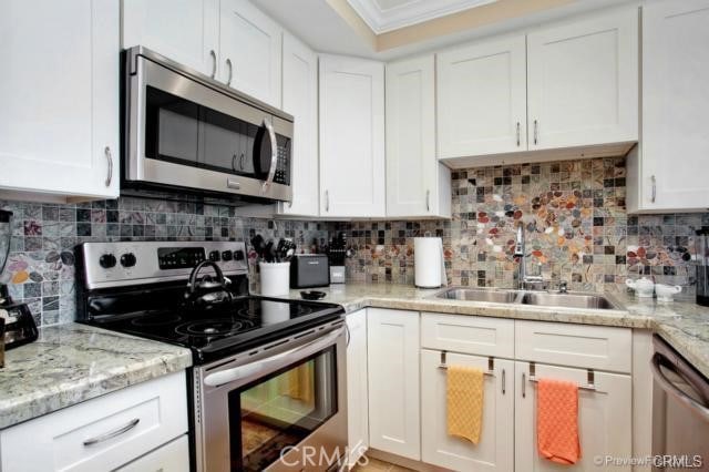 kitchen with white cabinets, stainless steel appliances, and tasteful backsplash