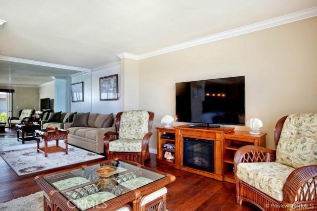 living room featuring dark hardwood / wood-style floors and crown molding