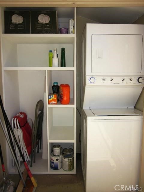 washroom featuring stacked washer / drying machine