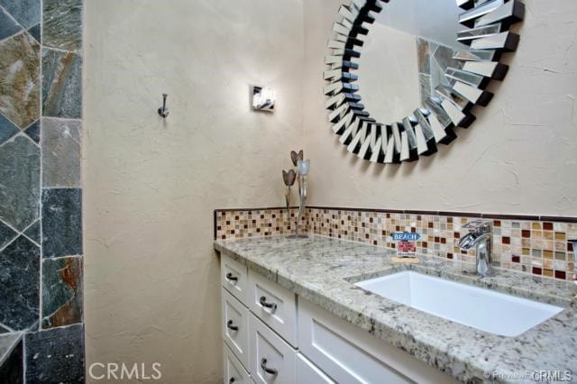 bathroom featuring decorative backsplash and vanity