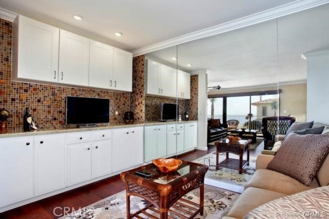 living room featuring dark hardwood / wood-style flooring and ornamental molding