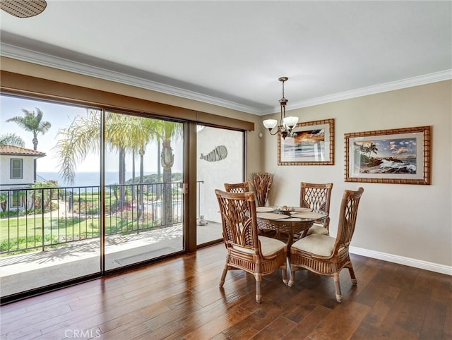 dining area with hardwood / wood-style flooring, baseboards, an inviting chandelier, and ornamental molding