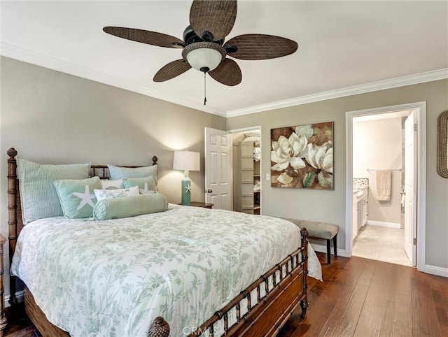 bedroom featuring dark wood-style floors, a ceiling fan, ornamental molding, connected bathroom, and baseboards