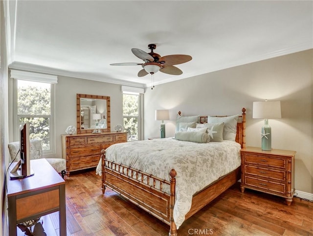 bedroom with crown molding, dark wood-style flooring, and multiple windows