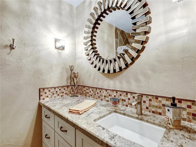 bathroom with a textured wall, a wood stove, vanity, and decorative backsplash