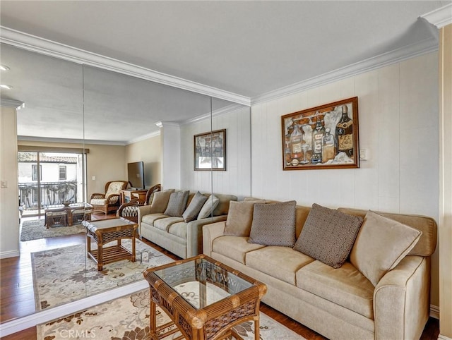 living room with wood finished floors, baseboards, and ornamental molding
