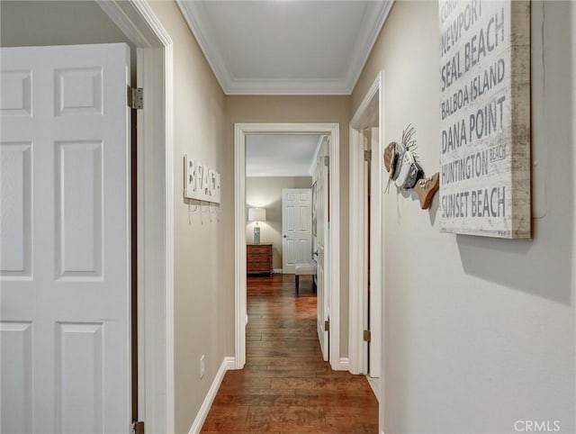 hall featuring baseboards, crown molding, and dark wood-style floors