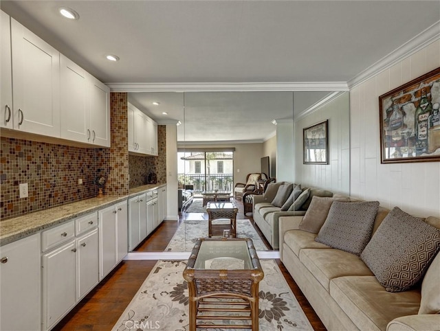 living area featuring dark wood-type flooring, ornamental molding, and recessed lighting