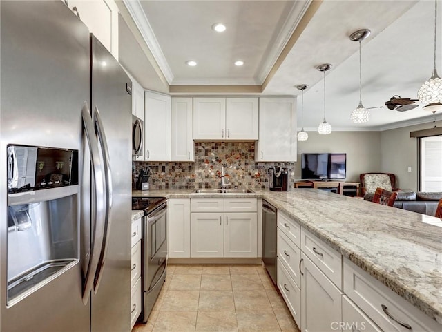 kitchen with tasteful backsplash, a sink, stainless steel appliances, white cabinetry, and ornamental molding