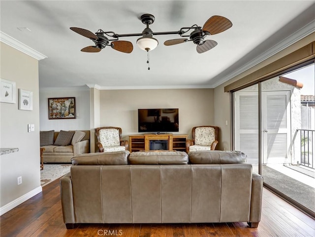 living area featuring ceiling fan, baseboards, crown molding, and dark wood-style floors