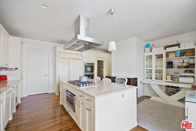 kitchen with pendant lighting, island range hood, stainless steel appliances, dark hardwood / wood-style flooring, and light stone countertops