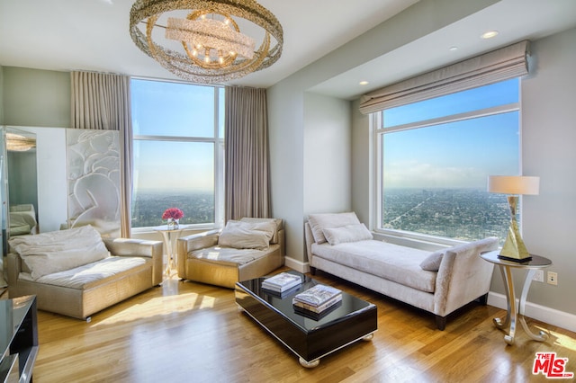 living room featuring a healthy amount of sunlight, a chandelier, and hardwood / wood-style flooring