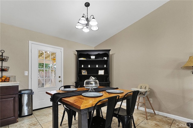 dining space with a notable chandelier, lofted ceiling, and light tile patterned flooring