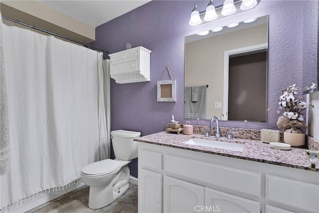 bathroom with walk in shower, vanity, and toilet