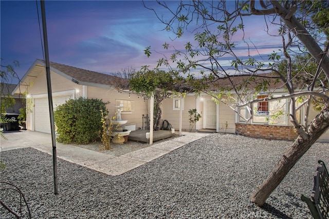 back house at dusk featuring a garage