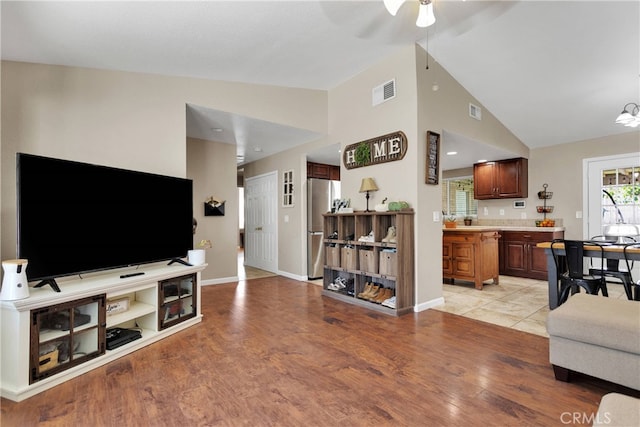 living room featuring high vaulted ceiling, light wood-type flooring, and ceiling fan