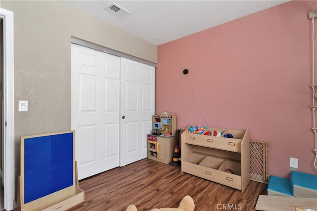 bedroom with dark hardwood / wood-style floors and a closet