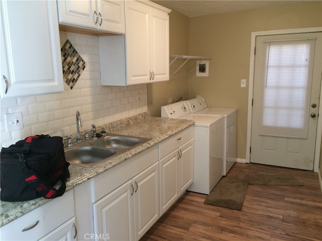 laundry room with cabinets, dark hardwood / wood-style floors, washer and dryer, and sink