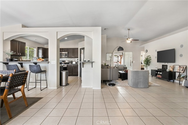 kitchen featuring vaulted ceiling, ceiling fan, appliances with stainless steel finishes, and dark brown cabinetry