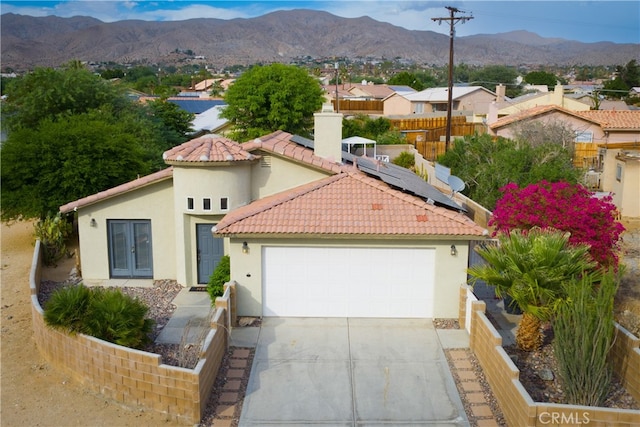 mediterranean / spanish house featuring a garage and a mountain view