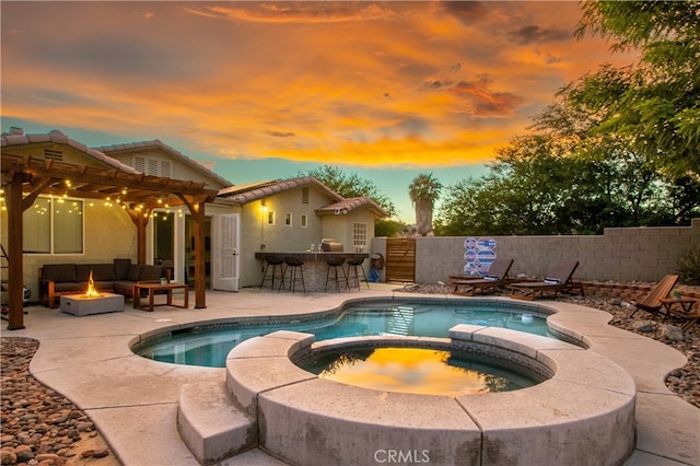 pool at dusk featuring a patio, exterior bar, an in ground hot tub, and outdoor lounge area