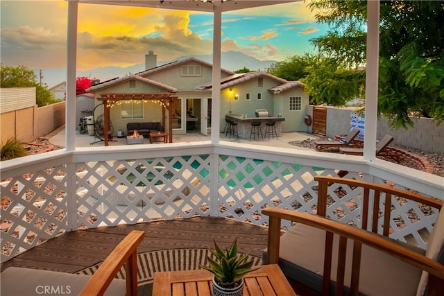 pool at dusk featuring outdoor lounge area, a gazebo, and a deck