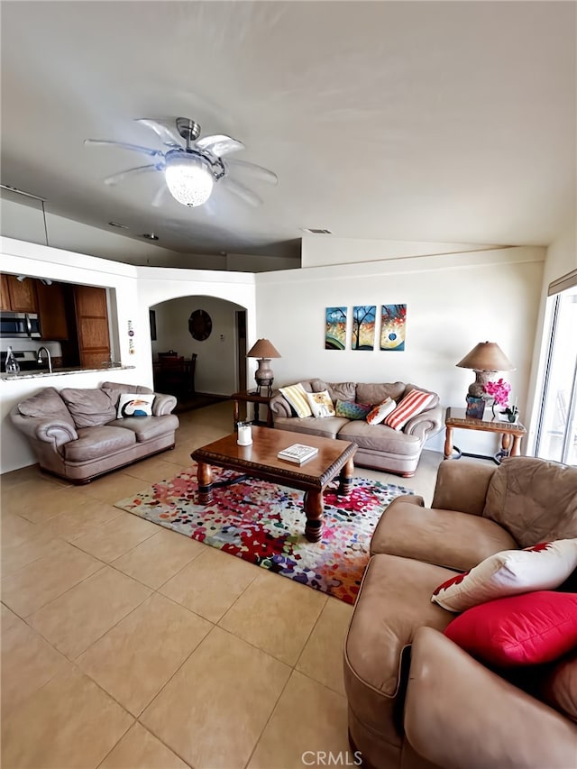 living room with light tile patterned floors, lofted ceiling, and ceiling fan