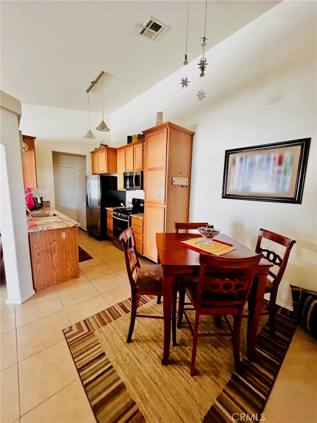 dining area featuring sink and light tile patterned floors