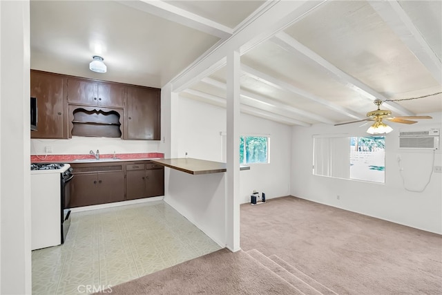 kitchen with ceiling fan, vaulted ceiling with beams, dark brown cabinets, white range with gas stovetop, and light colored carpet