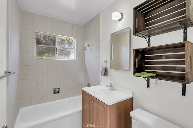 full bathroom with tiled shower / bath, vanity, and toilet