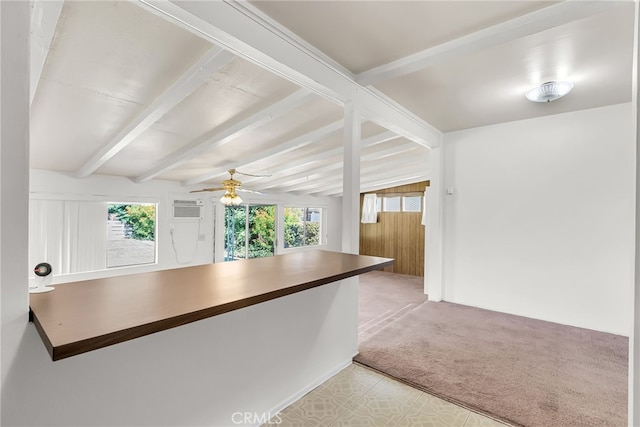 kitchen with light carpet, ceiling fan, beamed ceiling, and a healthy amount of sunlight