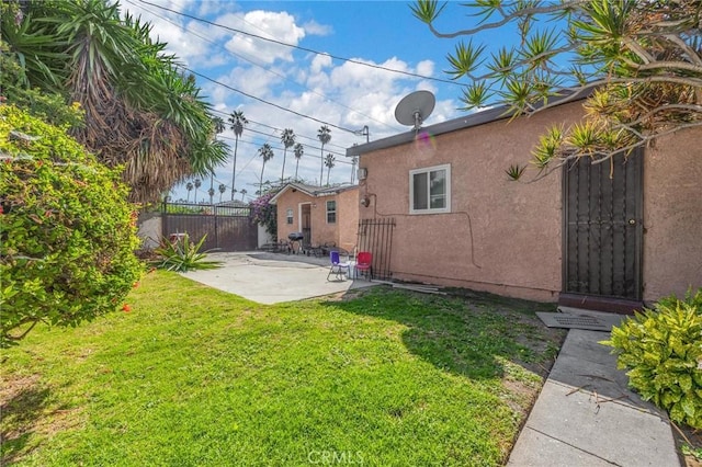 rear view of house featuring a patio area and a yard