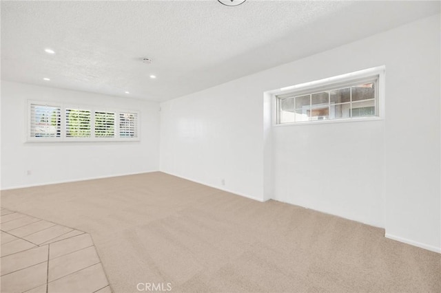 carpeted empty room featuring a textured ceiling