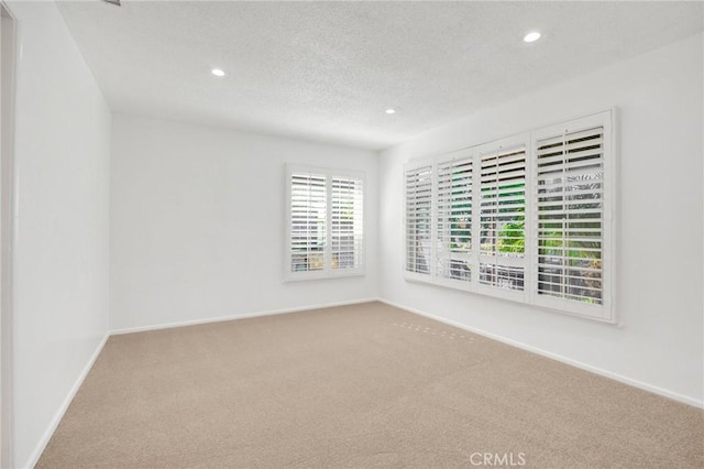 carpeted spare room featuring a textured ceiling