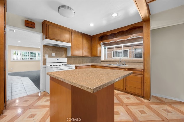 kitchen featuring white gas stove, sink, tasteful backsplash, light parquet floors, and a kitchen island