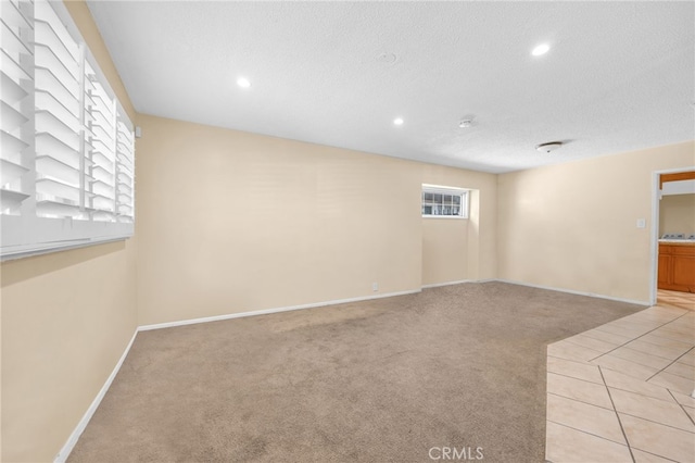 carpeted empty room featuring a textured ceiling