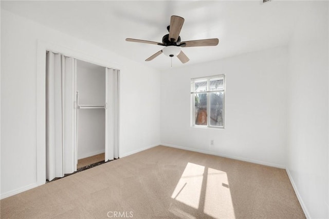 unfurnished bedroom featuring light carpet, a closet, and ceiling fan