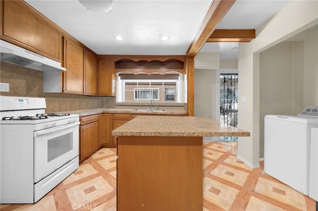 kitchen with a healthy amount of sunlight, white range with gas stovetop, extractor fan, and washer / clothes dryer