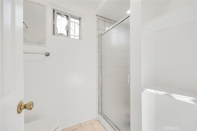 bathroom featuring tile patterned floors, toilet, and walk in shower