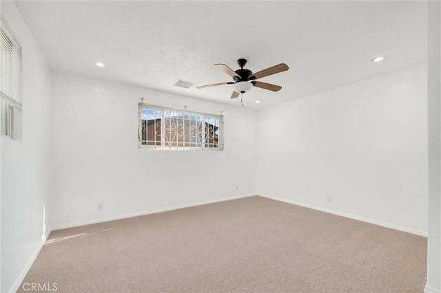 carpeted spare room featuring ceiling fan