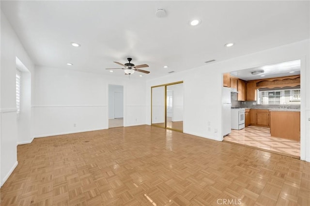 unfurnished living room featuring ceiling fan, sink, and light parquet flooring