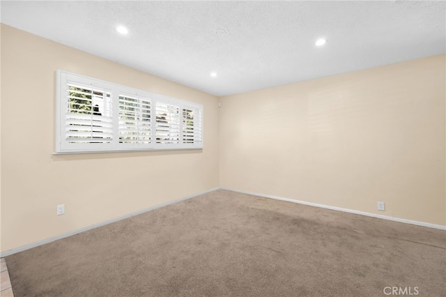 carpeted spare room with a textured ceiling