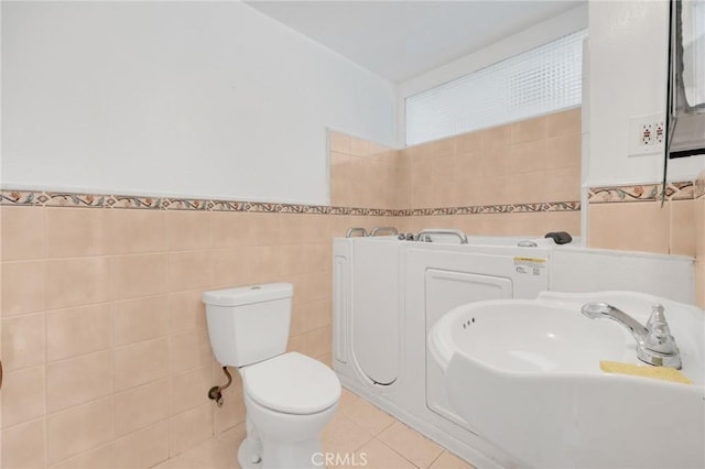 bathroom with tile patterned flooring, tile walls, and sink